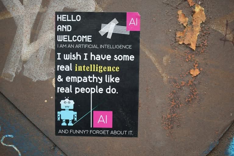 Sticker on rusty metal depicting AI wishing for human empathy.
