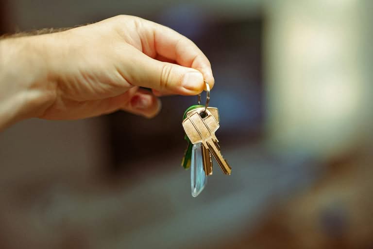A person's hand holding a set of house keys.